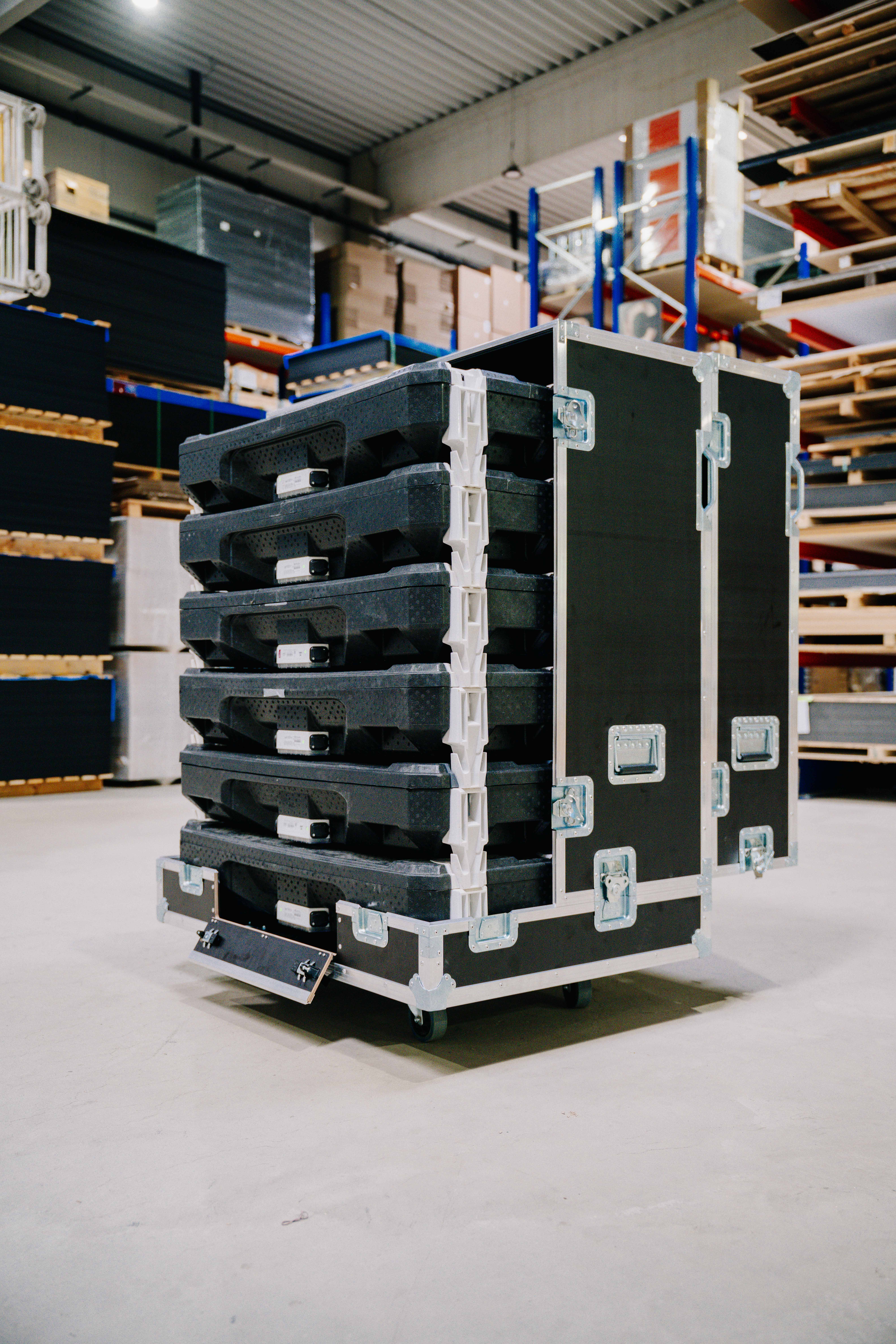 Stackbarer Flightcase mit mehreren herausziehbaren Kunststoffeinlagen in einer Werk- bzw. Lagerhalle.