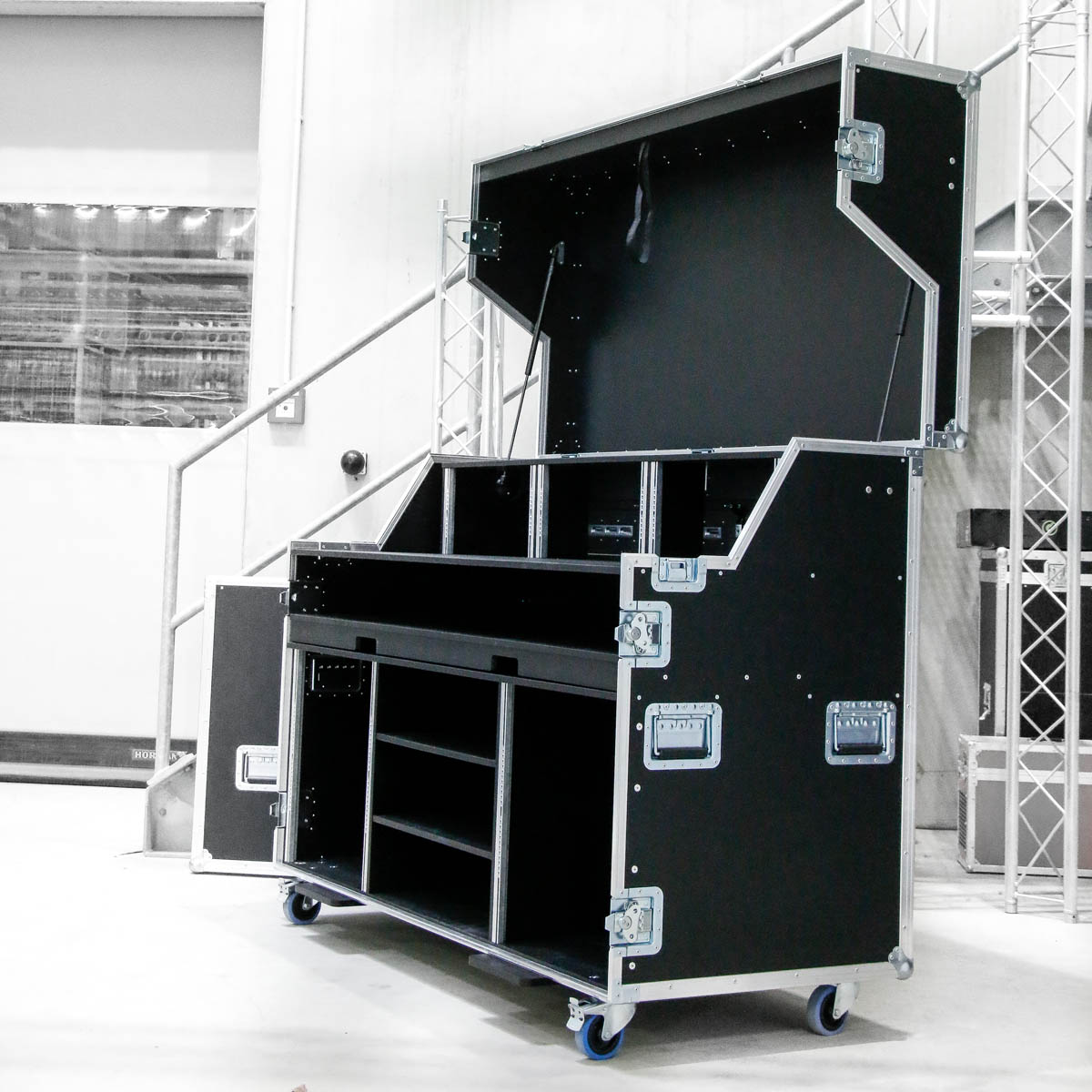 Geöffnetes Flightcase mit mehreren Fächern und Ablagen in einer Werkhalle.