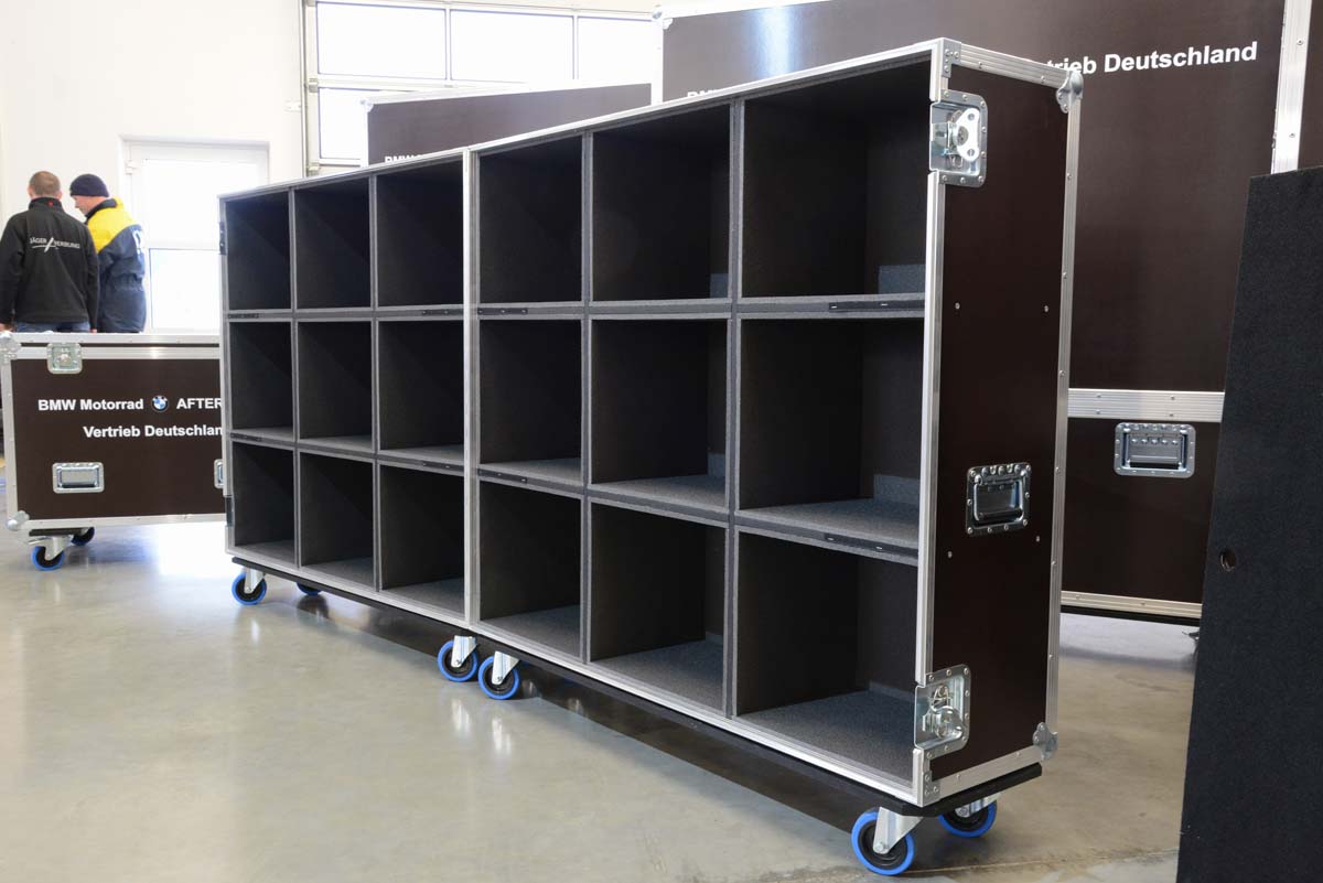 Großes Flightcase mit offenliegenden, gleichmäßigen Fächern auf Rollen.